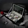 Cutie de ceas cu 12 compartimente, capac de sticlă, imitație de piele neagră, căptușeală bej-verzuie